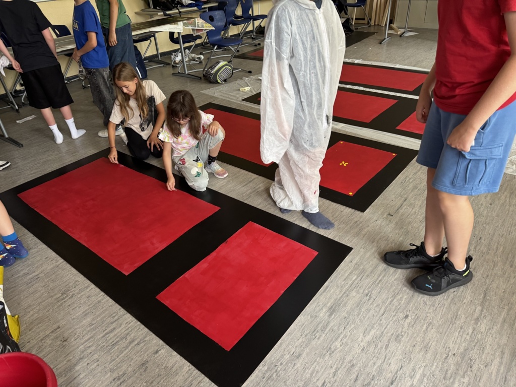 Römer_Wand bemalen Schülerinnen bemalen die Holztafeln, die einen pompeianischen Raum nachahmen.