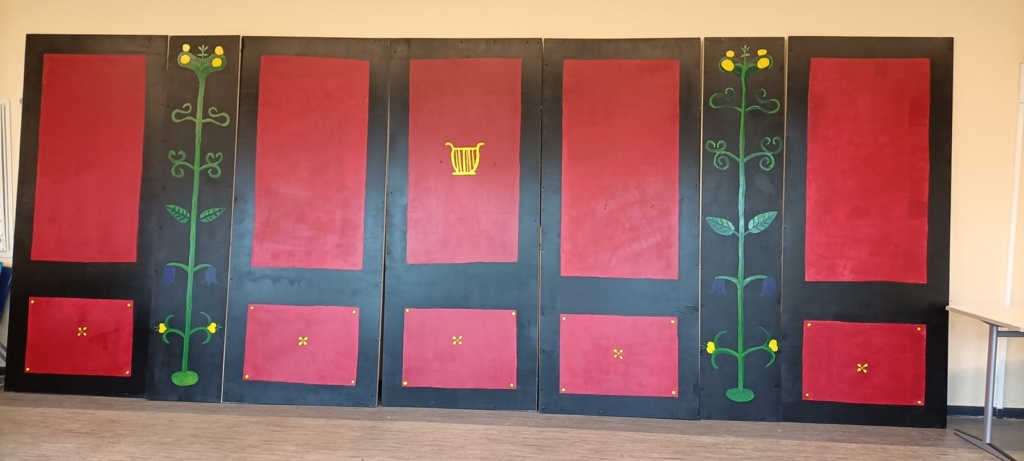 Rom_Kulisse Sieben hochformatige, bemalte Holztafeln ahmen pompeianischen Wandschmuck nach in Rot und Schwarz mit floralen Elementen.