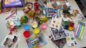 IMG-20251202-WA0012 Allerlei kleine bunte Plastikspielzeuge liegen auf einem Tisch.