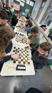 IMG-20251202-WA0015 14 Schüler beugen sich konzentriert über die Schachbretter.