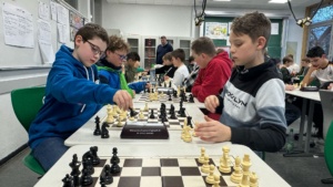 IMG-20251202-WA0018 14 Schüler beugen sich konzentriert über die Schachbretter.