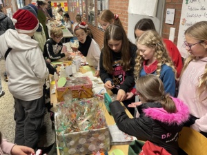 IMG_7388 Gutgelaunte Schülerinnen und Schüler verkaufen weihnachtliche Produkte.