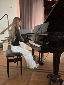 IMG_7399 Ein Mädchen spielt an einem schwarzen Flügel.