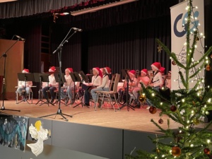 IMG_7407 Das Schülerblasorchester sitzt auf der Bühne.