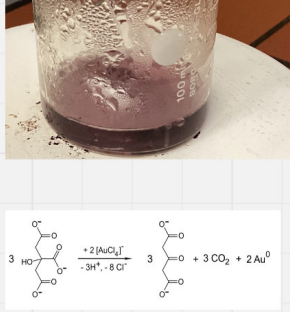 Der untere Teil eines Glaszylinders mit rotbrauner Flüssigkeit und Wassertropfen auf einer weißen Tischplatte mit rotbraunen Krümeln,