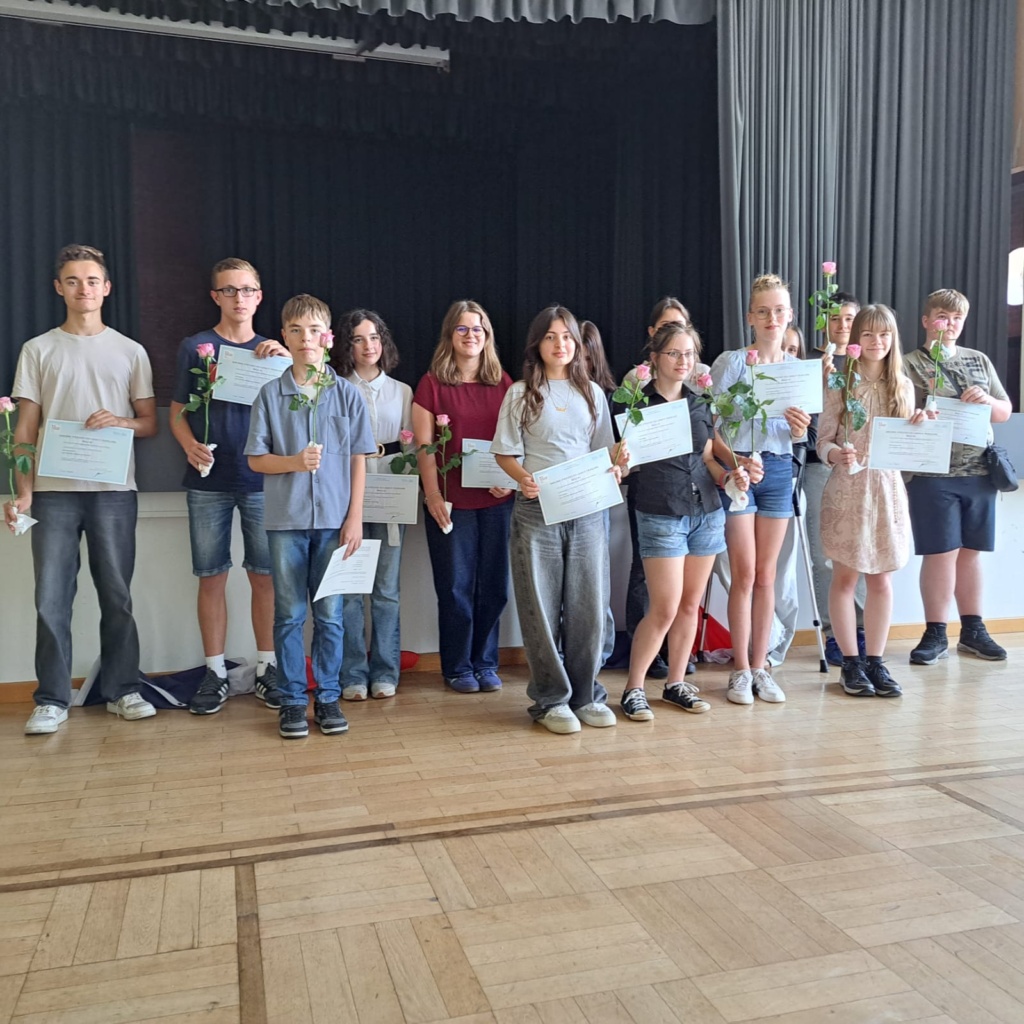 2026_DELF_Ehrung Eine Gruppe Schülerinnen und Schüler präsentieren in der Aula des Gymnasium Groß Ilsede stolz ihr Sprachzertifikat Französisch